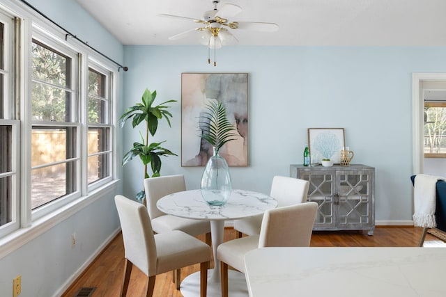 dining area featuring a ceiling fan, wood finished floors, and baseboards