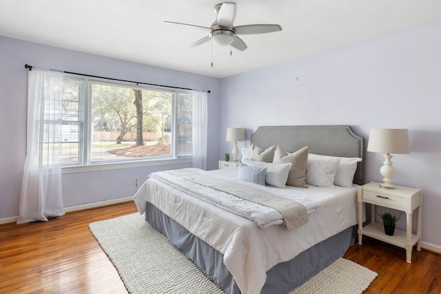 bedroom featuring a ceiling fan, baseboards, and wood-type flooring