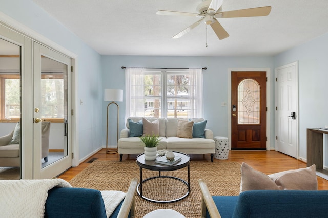 living area with wood finished floors, visible vents, and french doors