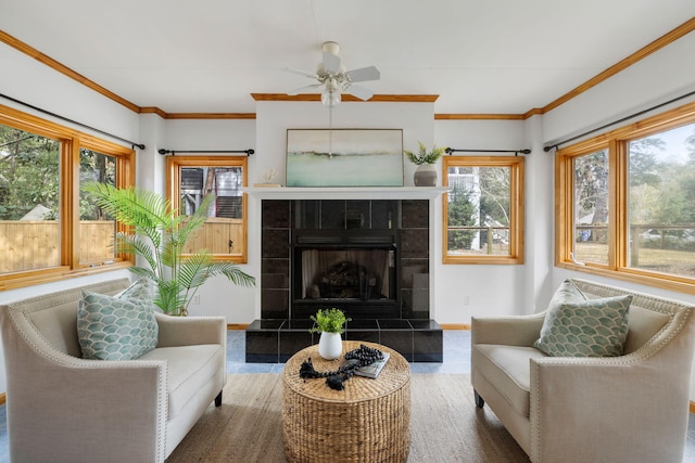 sunroom / solarium with a tiled fireplace and a ceiling fan