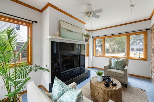 living area with ceiling fan, baseboards, and ornamental molding