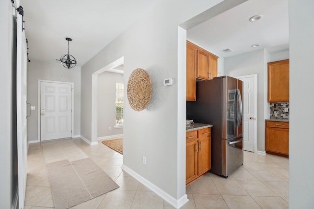 7511 Hawks Cir, Hanahan, SC 29410 - kitchen featuring freestanding refrigerator, decorative backsplash, a barn door, light tile patterned floors, and recessed lighting