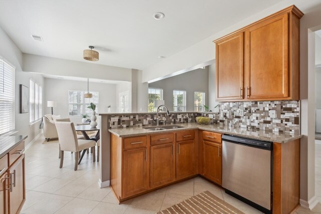 7511 Hawks Cir, Hanahan, SC 29410 - kitchen with dishwasher, brown cabinets, decorative backsplash, a peninsula, and light stone counters