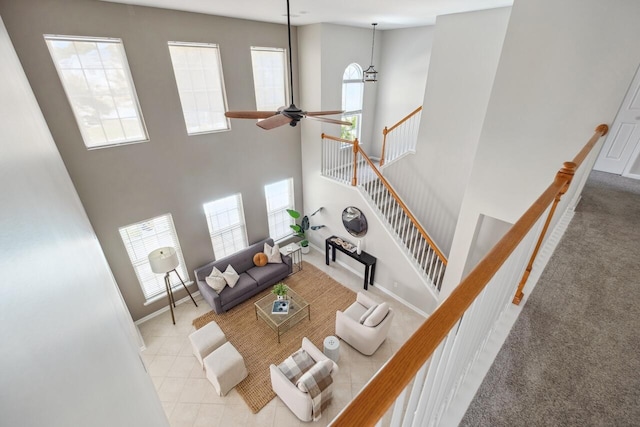 7511 Hawks Cir, Hanahan, SC 29410 - tiled living area with carpet floors, ceiling fan, a towering ceiling, and stairs