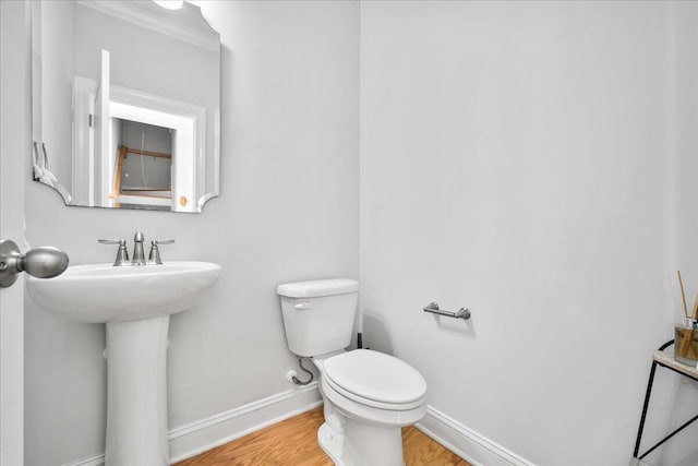 bathroom featuring toilet, baseboards, and wood finished floors