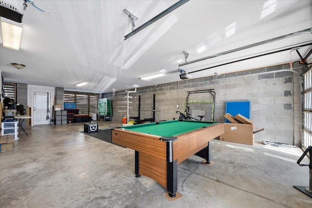 playroom featuring a garage, billiards, concrete floors, and concrete block wall