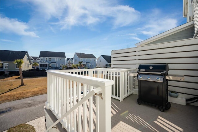 wooden terrace featuring grilling area and a residential view