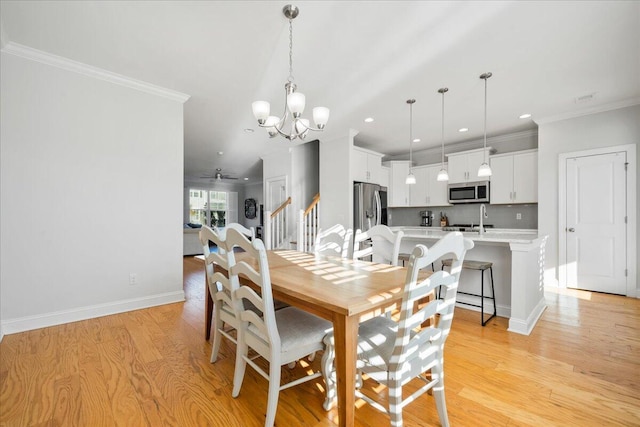 dining space featuring light wood-type flooring, crown molding, and baseboards