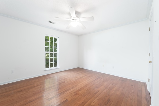 spare room with ceiling fan, ornamental molding, and wood-type flooring