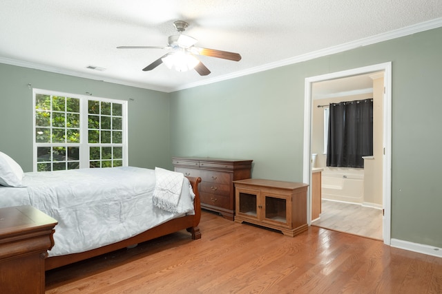 bedroom with ceiling fan, ensuite bath, light hardwood / wood-style flooring, and crown molding