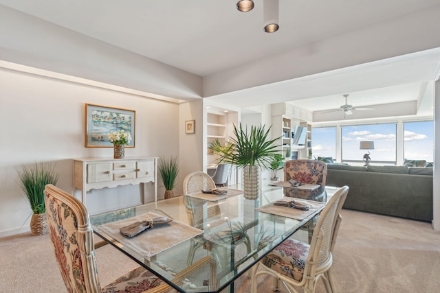 dining room featuring ceiling fan and light carpet