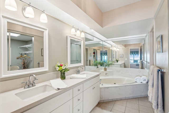 bathroom with tile patterned floors, a bathing tub, and vanity