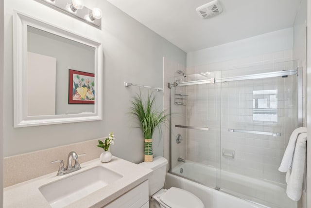 full bathroom featuring shower / bath combination with glass door, toilet, and vanity