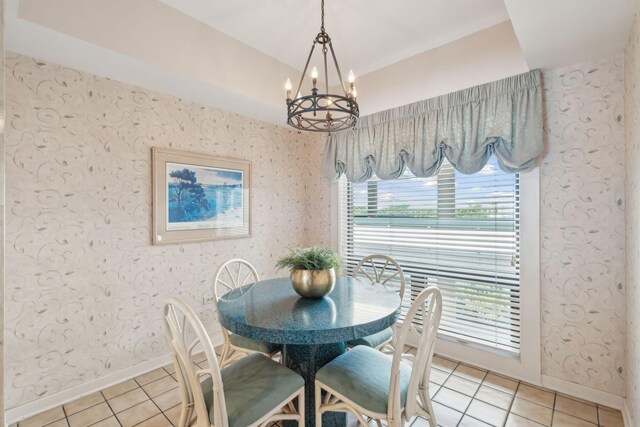 tiled dining space featuring a notable chandelier and plenty of natural light