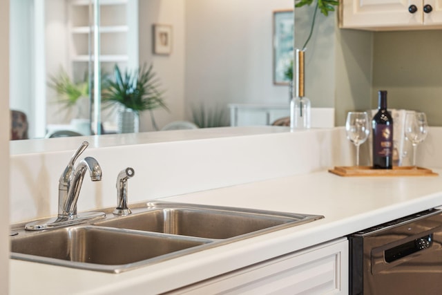 interior space featuring sink, white cabinetry, and black dishwasher