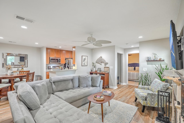 living room featuring light hardwood / wood-style flooring and ceiling fan