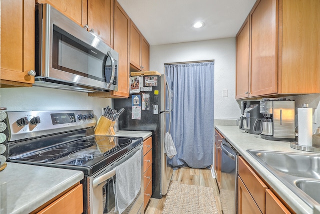 kitchen featuring sink, light wood-type flooring, and appliances with stainless steel finishes