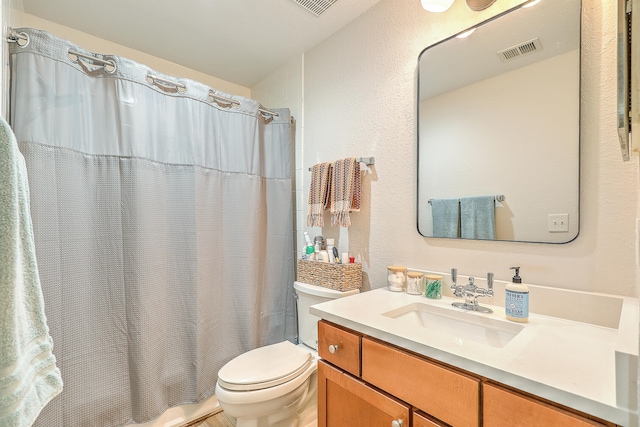 full bathroom with vanity, shower / bath combo, and toilet