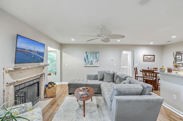 living room featuring ceiling fan and light hardwood / wood-style flooring