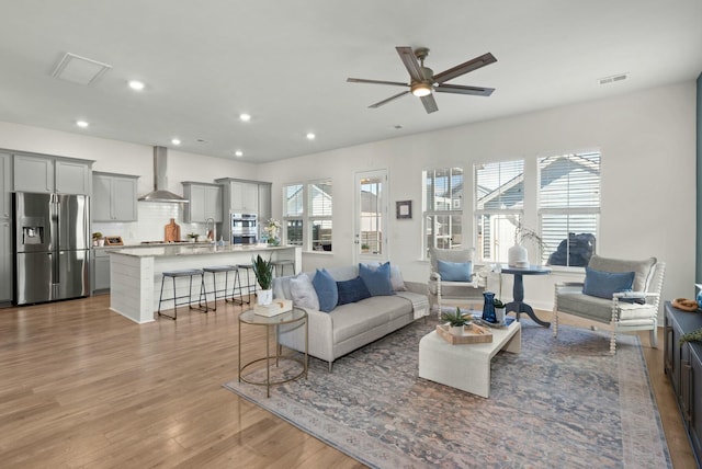 living area with plenty of natural light, wood finished floors, visible vents, and recessed lighting