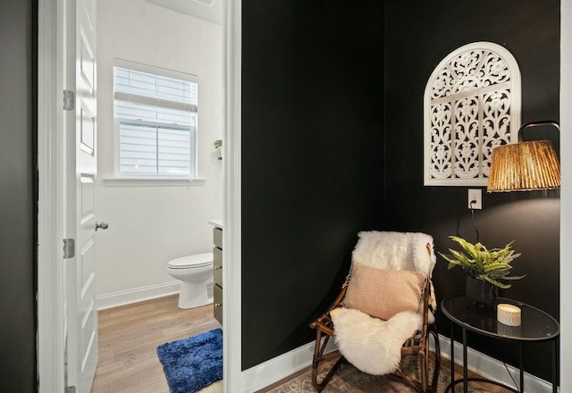 bathroom with toilet, baseboards, and wood finished floors