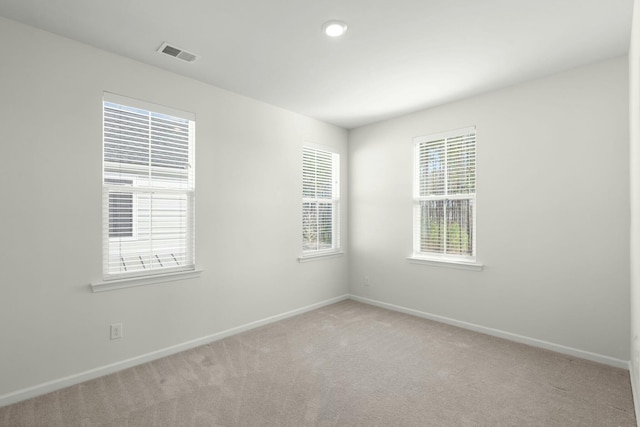 carpeted empty room with visible vents and baseboards