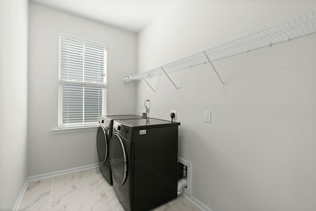 laundry room featuring marble finish floor, baseboards, and washing machine and clothes dryer