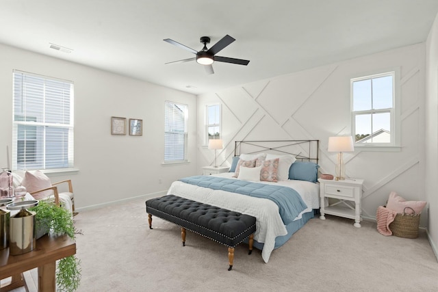 carpeted bedroom with a ceiling fan, visible vents, and baseboards