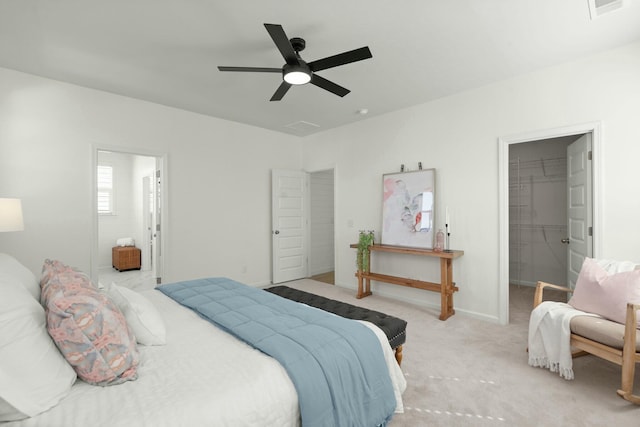 carpeted bedroom with a walk in closet, a closet, a ceiling fan, ensuite bath, and baseboards