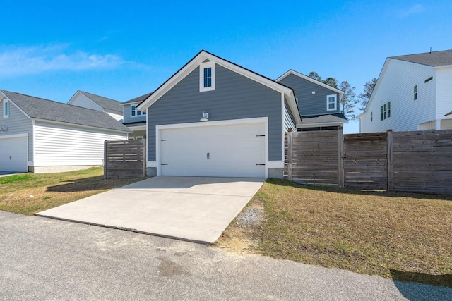 view of front of property with concrete driveway, fence, and a front lawn