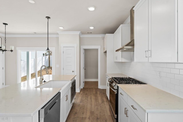 kitchen with white cabinets, stainless steel appliances, backsplash, light hardwood / wood-style floors, and decorative light fixtures