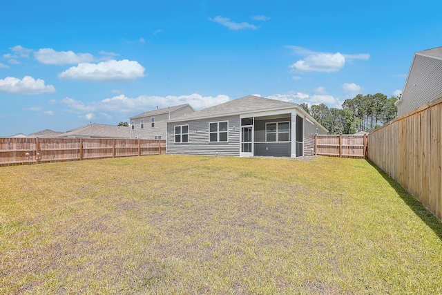 rear view of property with a yard and a sunroom