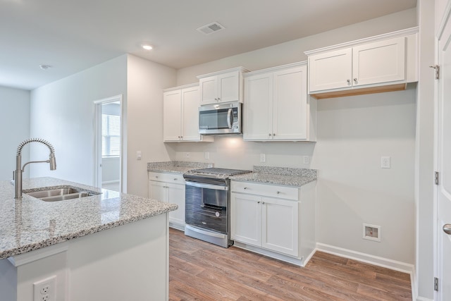 kitchen featuring light stone countertops, sink, white cabinetry, and stainless steel appliances