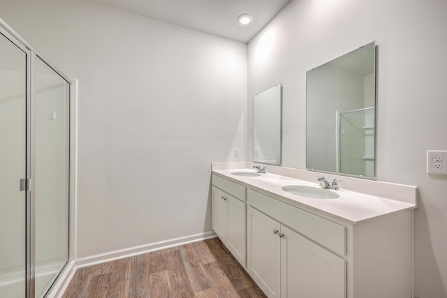 bathroom featuring walk in shower, vanity, and wood-type flooring