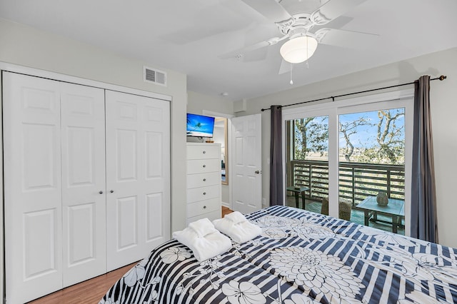 bedroom featuring ceiling fan, visible vents, a closet, and wood finished floors