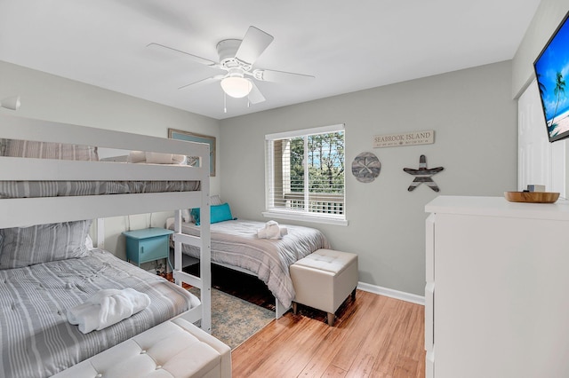 bedroom featuring light wood-style floors, baseboards, and a ceiling fan