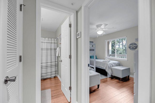 bedroom featuring light wood-type flooring, a ceiling fan, and baseboards