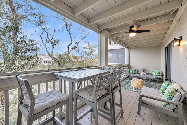 wooden deck with outdoor lounge area and a ceiling fan