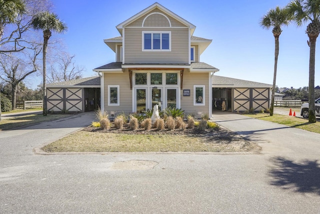 view of front facade featuring aphalt driveway, a shingled roof, and fence