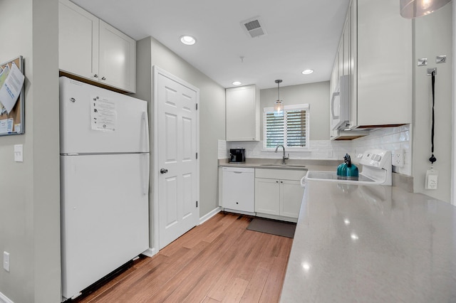 kitchen featuring light countertops, white appliances, a sink, and white cabinets