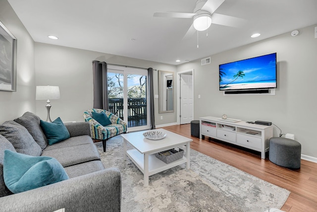 living area with recessed lighting, visible vents, baseboards, and wood finished floors