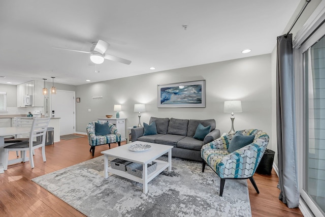 living area with light wood finished floors, a ceiling fan, and recessed lighting