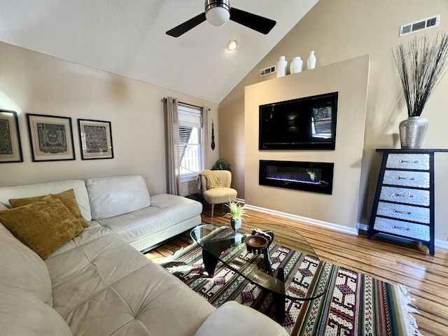 living room featuring hardwood / wood-style floors, ceiling fan, and vaulted ceiling