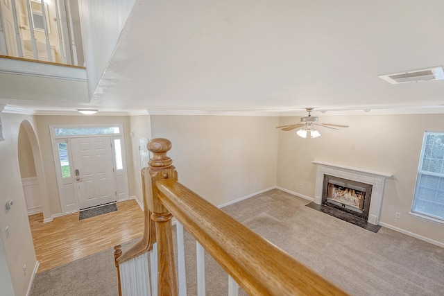 1308 Wild Olive Dr, Mount Pleasant, SC 29464 - foyer featuring ornamental molding, light carpet, a fireplace with flush hearth, a ceiling fan, and arched walkways