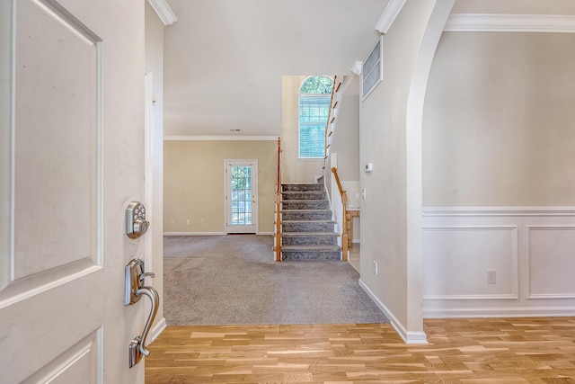 1308 Wild Olive Dr, Mount Pleasant, SC 29464 - foyer entrance with stairs, arched walkways, light wood-style floors, and crown molding