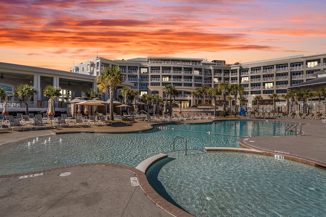 pool at dusk featuring a patio area