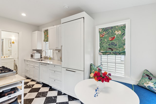 kitchen with white cabinetry, a healthy amount of sunlight, and sink