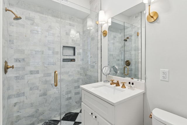 bathroom featuring vanity, toilet, and an enclosed shower