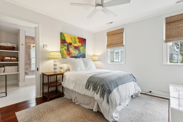 bedroom featuring ceiling fan, ensuite bathroom, dark wood-type flooring, and ornamental molding