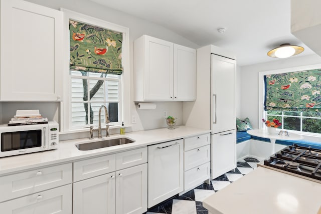 kitchen featuring sink, white cabinets, and white appliances